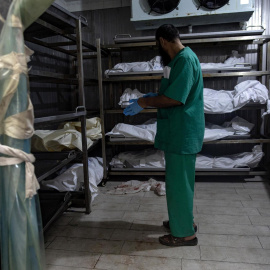 Un médico idenifica a los asesinados en los últimos ataques del Ejército israelí en Gaza, a 12 de agosto.