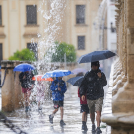 Foto de archivo de transeúntes  con paraguas durante las fuertes lluvias, en Sevilla.