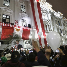 Simpatizantes del presidente electo de Perú, Pedro Castillo, y su vicepresidenta Dina Boluarte, se congregan bajo un balón para recibirlos en la Plaza San Martín, luego de recibir las credenciales de sus cargos el pasado 23 de julio, en Lima (Perú).
