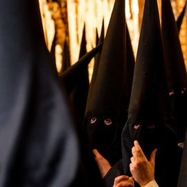Nazarenos de la Hermandad de Santa Genoveva, en el interior del templo, en la Semana Santa de Sevilla, a 11 de abril del 2022.