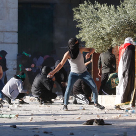 Los palestinos se enfrentan con la policía israelí dentro del complejo de la mezquita de Al-Aqsa después de que la policía israelí ingresara al complejo antes del amanecer mientras miles de musulmanes se reunían para rezar durante el mes sagrado del