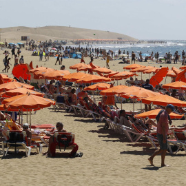turistas disfrutan este jueves en la playa de Maspalomas (Gran Canaria), donde se registran cielos despejados y temperaturas sobre los 24 grados.