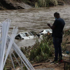 Dos automóviles se sumergen en las aguas de la inundación cerca de Durban, Sudáfrica, el 12 de abril de 2022.