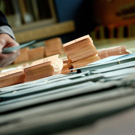 Una persona elige sus papeletas en un colegio electoral de Pamplona este domingo 26 de mayo | EFE/ Villar López