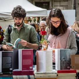 Dos personas miran libros en el día de Sant Jordi en Barcelona.