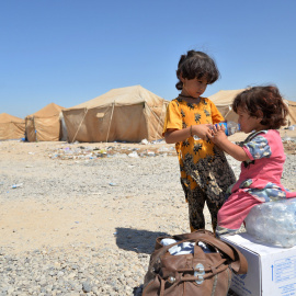 Niños iraquíes migrantes desde Siria reciben suministros de ayuda en un campamento de refugiados en Baiji, al norte de Bagdad. REUTERS/Stringer