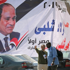 09/04/2019 - Dos hombres frente a un cartel del presidente egipcio Abdel Fattah al-Sisi días antes del referéndum para reformar la Constitución. / REUTERS - MOHAMED ABD EL GHANY