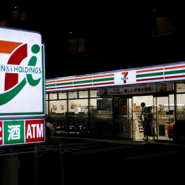 Una pareja salte de comprar en una tienda de conveniencia 7-Eleven en Tokio. REUTERS/Yuya Shino