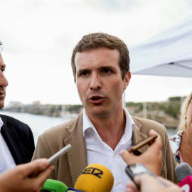 23/08/2018.- El presidente del PP, Pablo Casado (c), junto al presidente del partido en Baleares, Biel Company (i), y la presidenta del PP de Menorca, Misericordia Sugrañes (d), atiende a los medios de comunicación durante la visita que realiza hoy al C