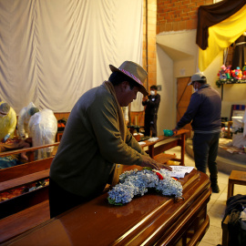 Un hombre deja flores sobre el ataúd de uno de los muertos en durante los enfrentamientos en la planta de gas de Senkata, en la ciudad de El Alto, Bolivia.-  REUTERS/David Mercado