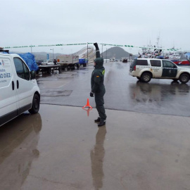 Agentes de la Guardia Civil controlan el acceso al puerto de Santoña, tras conocerse que un pesquero ha hallado a primera hora de esta mañana el cuerpo de una persona joven flotando. | EFE