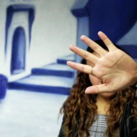 Imagen de una mujer tapándose la cara.