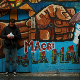Un hombre junto a una pintada contra el presidente Mauricio Macri, en Buenos Aires. REUTERS/Marcos Brindicci