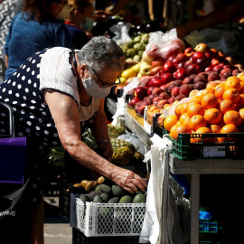 Una persona compra en el mercadillo semanal de Montcada i Reixac. /  EFE - Quique García