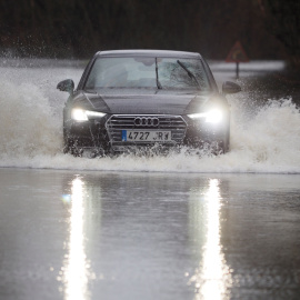 19/12/2019.- Un coche cruza la carretera LU-P-1701, en Muimenta, Lugo, inundada por el agua de los ríos Pequeño y Miño. EFE/ Eliseo Trigo
