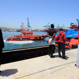 Varios migrantes observan la llegada de una embarcación de Salvamento Marítimo con 19 migrantes rescatados en el estrecho de Gibraltar. EFE/A. Carrasco Ragel