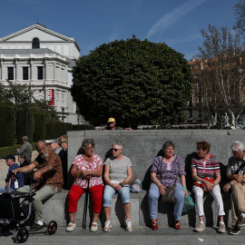 Varios turistas sentados cerca del Teatro de la Ópera, en el centro de Madrid. REUTERS/Susana Vera