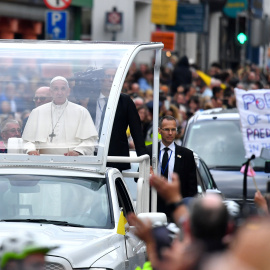 Francisco, en el Papamóvil, pasa junto a una pancarta de protesta contra los abusos a menores de la Iglesia. - REUTERS