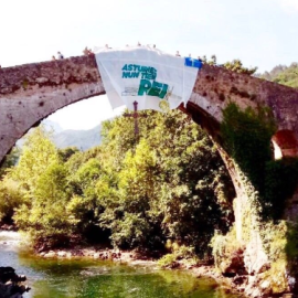 La pancarta en el puente romano de Cangas de Onís en contra de la presencia de los reyes. | Facebook de Lluchando Pola Soberanía