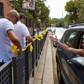 Una mujer increpa a miembros a dos personas que retiran lazos amarillos en la localidad de Alella. (ALEJANDRO GARCÍA | EFE)