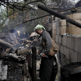 14/05/2022 Vera Kosolopenko camina entre los escombros de su vivienda, destruida por los bombardeos rusos en Derhachi, cerca de Járkov (Ucrania)