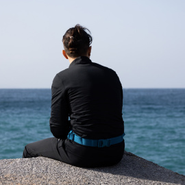 Mohamed (nombre ficticio) se sienta en las rocas cercanas al puerto de Ceuta. Vive en las calles de la ciudad desde que entró durante la crisis fronteriza con Marruecos del pasado mayo.