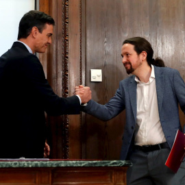 30/12/2019.- El candidato a la investidura, Pedro Sánchez (i), y el líder de Podemos, Pablo Iglesias (d), estrechan su s manos durante el acto de firma del acuerdo programático. / EFE - JUANJO MARTÍN