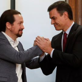 El candidato a la investidura, Pedro Sánchez (d), y el líder de Podemos, Pablo Iglesias (i), estrechan sus manos tras el acto de firma del acuerdo programático con las principales medidas que tomará el futuro Gobierno de coalición.EFE/JuanJo Martín