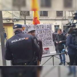 Un policía disuade al hombre que protestaba frente a Ferraz en defensa de la unidad de España./ Europa Press