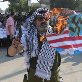 Un palestino quema una bandera de Estados Unidos en una protesta en el paso de Erez contra la decisión de la Administración Trump de suspender la financiación a la UNRWA. - AFP