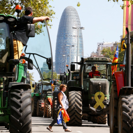 Una mujer camina entre tractores el día de la Diada en Barcelona, que está marcado por un clima político cargado. /  REUTERS - ENRIQUE CALVO