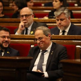 El vicepresident i el president de la Generalitat, Pere Aragonès i Quim Torra, somriuen en els seus escons durant un ple extraordinari convocat després de la decisió de la Junta Electoral Central (JEC) d'inhabilitar Torra. Pau Venteo / Europa Press