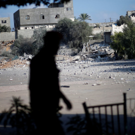 Un miembro de las fuerzas de seguridad palestinas de Hamas camina frente a las ruinas de un edificio tras un ataque aéreo israelí. / REUTERS - MOHAMMED SALEM