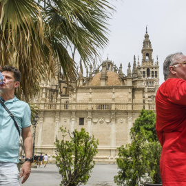 Turistas se refrescan en el centro de Sevilla en un día en el que las altas temperaturas son propias del verano.