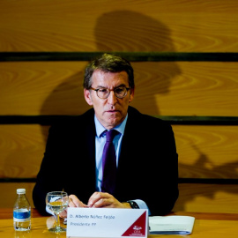 El presidente del PP, Alberto Núñez Feijóo, escucha atentamente a el candidato del PP-A a la reelección, Juanma Moreno, que interviene en un encuentro con empresarios andaluces a 18 de mayo del 2022 en Sevilla (Andalucía, España)