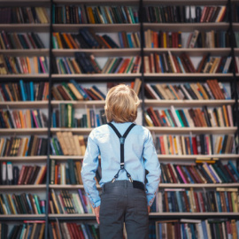 Imagen de archivo de un niño mientras observa una librería/ Adobestock