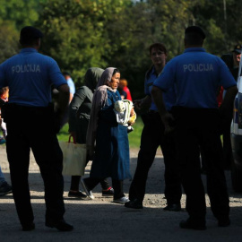 Agentes de la Policía croata escolta na varios migrantes. - REUTERS