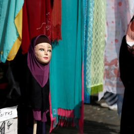 Una mujer con velo pasa junto a una tienda de venta de pañuelos en una imagen de archivo. / REUTERS - FRANCOIS LENOIR