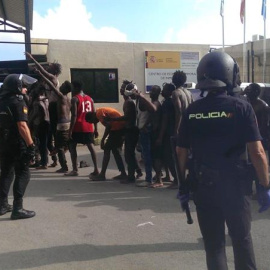 Migrantes custodiados por efectivos de la Policía Nacional esperan su entrada al Centro de Estancia Temporal de Inmigrantes (CETI) de Ceuta, tras conseguir saltar la valla fronteriza. EFE/José M. Rincón
