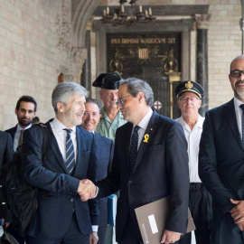 El presidente de la Generalitat,Quim Torra, junto al conseller de Interior Miquel Buch, a la detrecha, saluda al ministro de Interior, Fernando Grande-Marlaska. (MARTA PÉREZ | EFE)