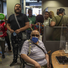 Activistas por el derecho a la vivienda protestan en una sucursal de CaixaBank en Vallecas (Madrid) para evitar una "oleada de desahucios".