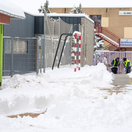 Operarios trabajando en un colegio de Ávila este domingo para quitar la nieve acumulada.