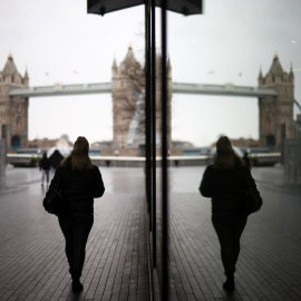 Una mujer camina cerca del Tower Bridge en Londres, Reino Unido