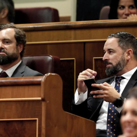 El presidente de Vox, Santiago Abascal (d), y el portavoz Iván Espinosa de los Monteros, durante el debate de investidura. /EFE