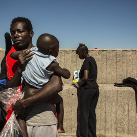 Una mujer subsahariana sostiene a su hijo antes de ser trasladados a otra parte del puerto de Algeciras. Cerca e 400 migrantes han pasado varias días enteros en los barcos de rescate o en el suelo por falta de espacio en otros lugares. JAIRO VARGAS