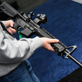 Un joven sostiene un rifle exhibido durante la reunión anual de la Asociación Nacional del Rifle (NRA) en el Centro de Convenciones George R. Brown, en Houston, Texas, el 28 de mayo de 2022.