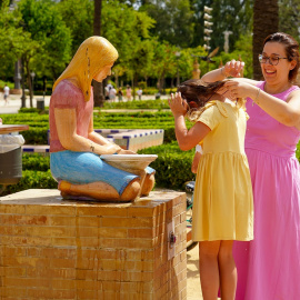 Una madre refresca a su hija en una fuente de el Parque de Maria Luisa en la primera ola de calor con temperaturas que sobrepasaran los 40 grados a 12 de junio del 2022 en Sevilla (Andalucía, España)