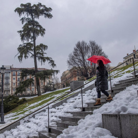 Una viandante baja una escalinata cerca del madrileño Museo del Prado bajo la lluvia, este miércoles