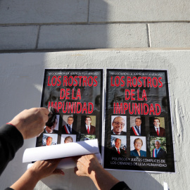 Chilenos pegan carteles en la pared con imágenes de los políticos del país que hacen llamar "los rostros de la impunidad" - Reuters