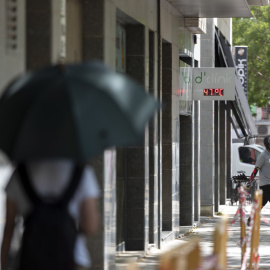 15/06/2022 Una joven camina por una calle bajo un termómetro que indica los 47ºC este miércoles, tercer día de ola de calor en Cataluña, que, según las previsiones, aún será más sofocante mañana, para alcanzar su máximo el viernes, a 15 de juni